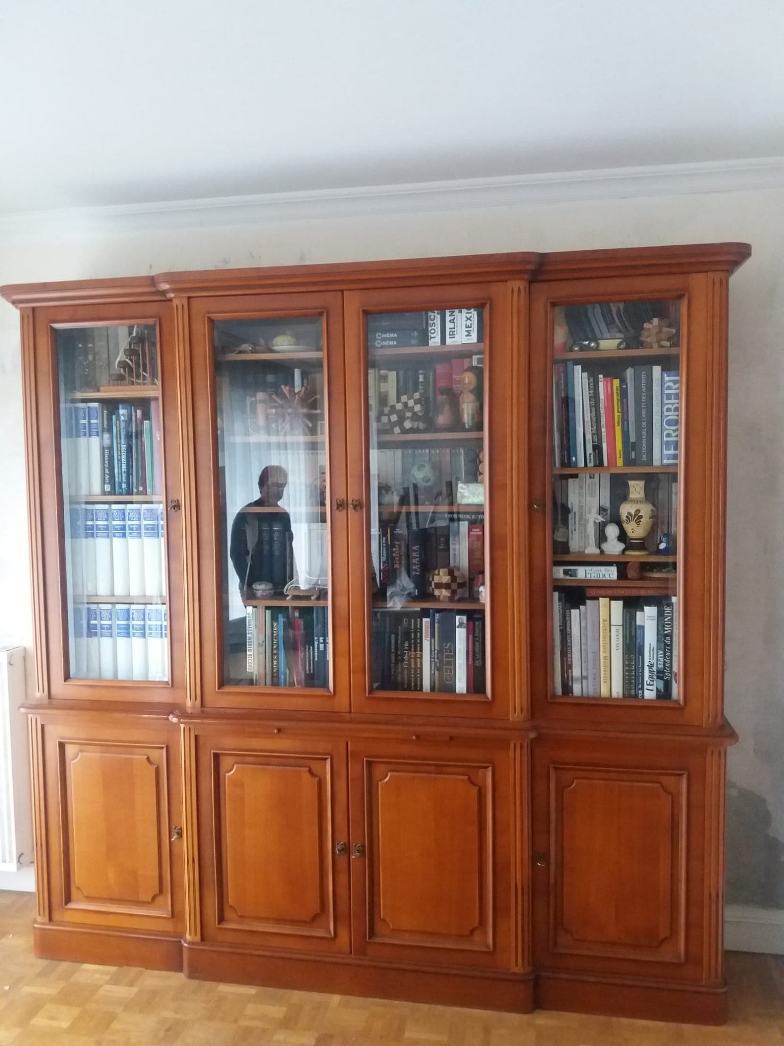 Bibliothèque-vitrine deux corps en merisier massif à avant-corps central : quatre portes vitrées sur tablettes réglables, quatre portes à panneaux moulurés en partie basse, pilastres cannelés