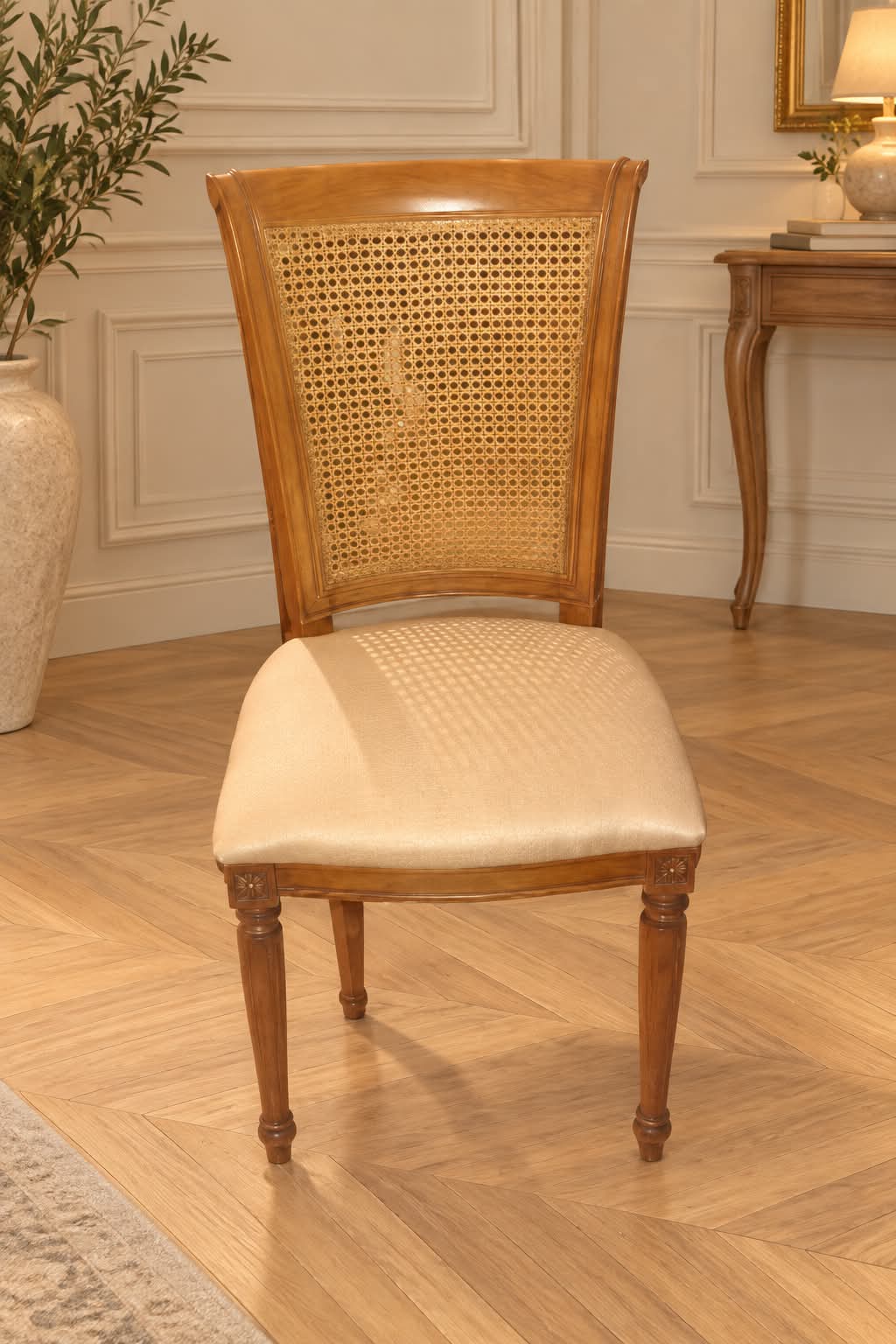 Chaise Louis-Philippe en merisier massif à dossier canné en crosse et assise garnie d’un tissu ivoire satiné, dés sculptés de rosaces et pieds avant fuselés