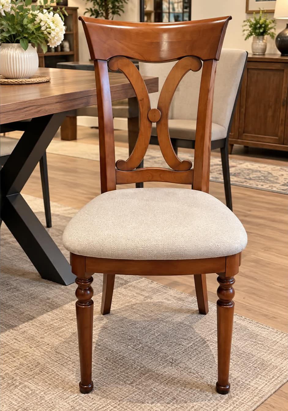 Chaise Louis-Philippe en merisier massif, dossier à bandeau cintré en crosse et deux volutes affrontées réunies par une pastille, assise garnie de tissu grège, pieds avant tournés