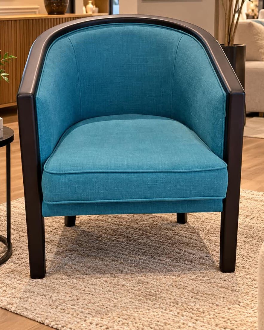 Fauteuil Art déco à dossier gondole cerclé d’un bandeau de bois sombre prolongé en pieds avant, garni de tissu bleu canard avec coussin d’assise passepoilé