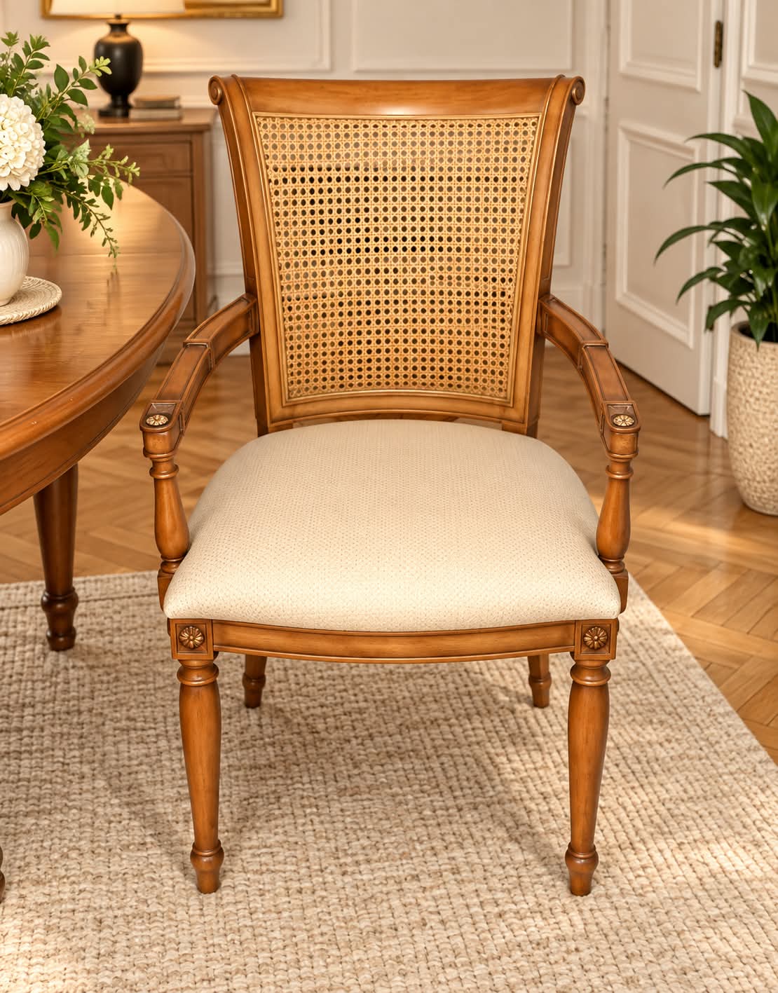Fauteuil en merisier massif à dossier canné en crosse, accotoirs moulurés sur supports en balustre terminés par des rosaces, assise garnie de tissu ivoire et pieds avant fuselés