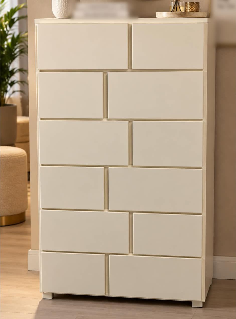 Chiffonnier contemporain laqué crème à douze tiroirs sans poignée disposés en quinconce, façon mur appareillé, sur petits pieds en retrait