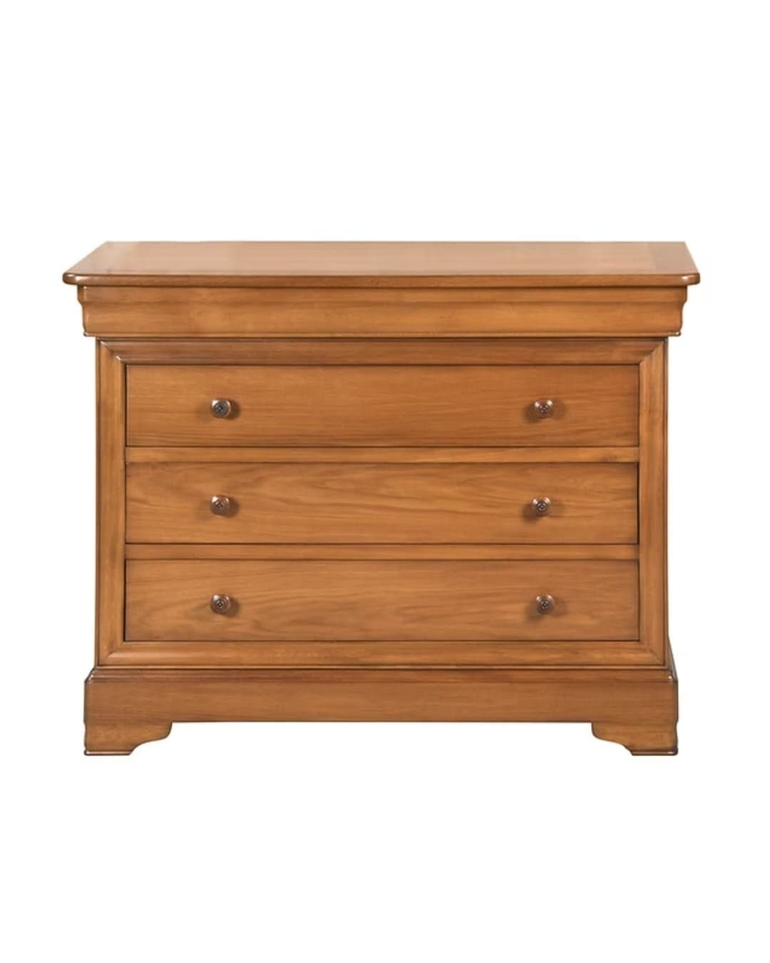 Commode Louis-Philippe en merisier massif : trois tiroirs à boutons ronds, quatrième tiroir dissimulé dans la ceinture en doucine, montants arrondis en colonne, plateau mouluré et socle à pieds découpés
